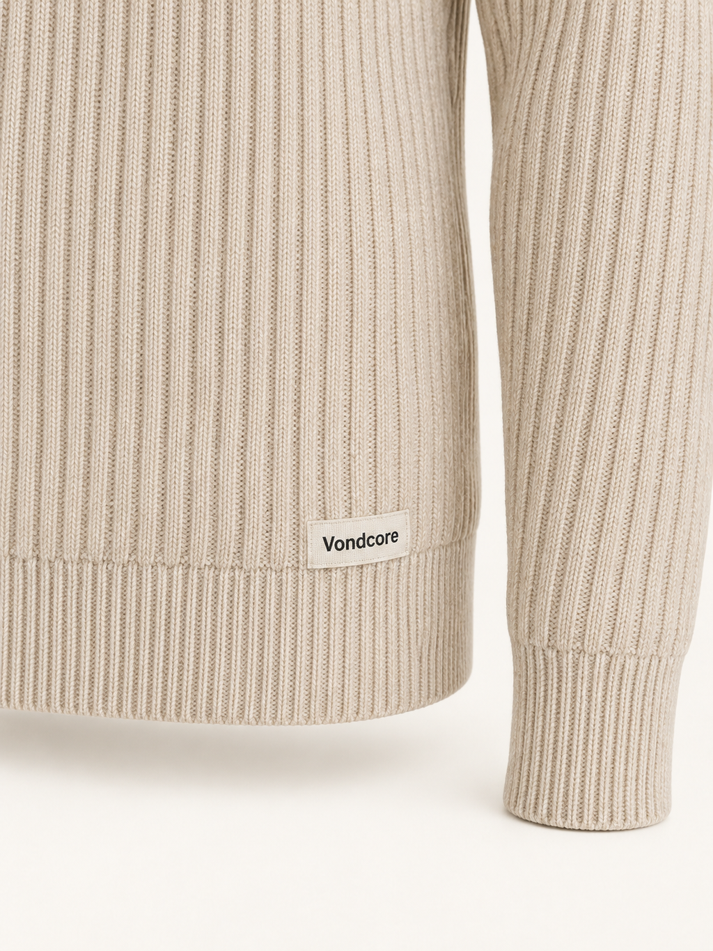Detail of the oatmeal Vondcore Alpine Rib Crew Sweater showing rib knit texture, cuff, hem and woven Vondcore label.