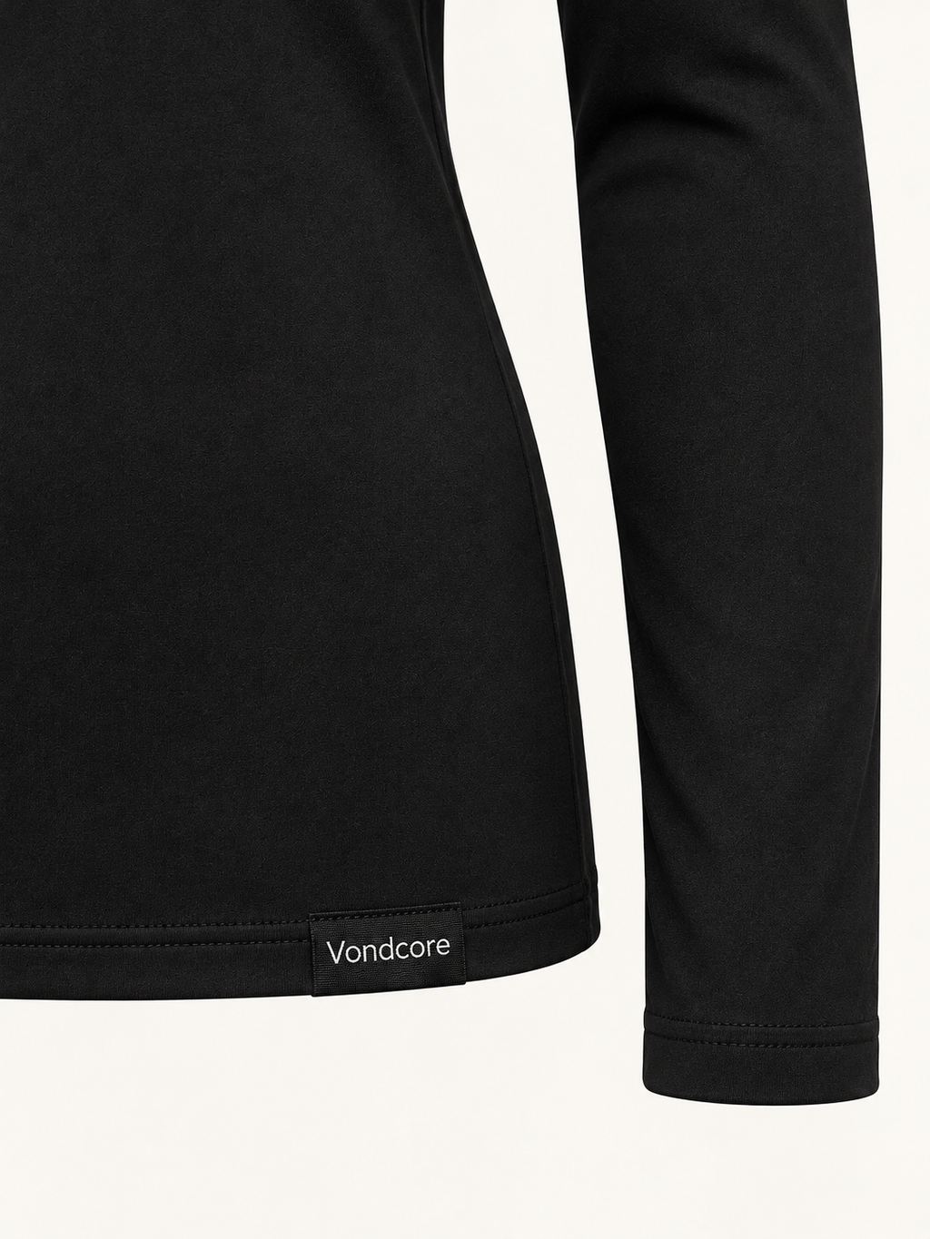 Detail of the black Vondcore Base Long-Sleeve Layer showing smooth fabric, sleeve cuff, hem and Vondcore woven label.